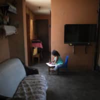 A kindergarten student does schoolwork at home in Caracas, Venezuela, in April.  | AP