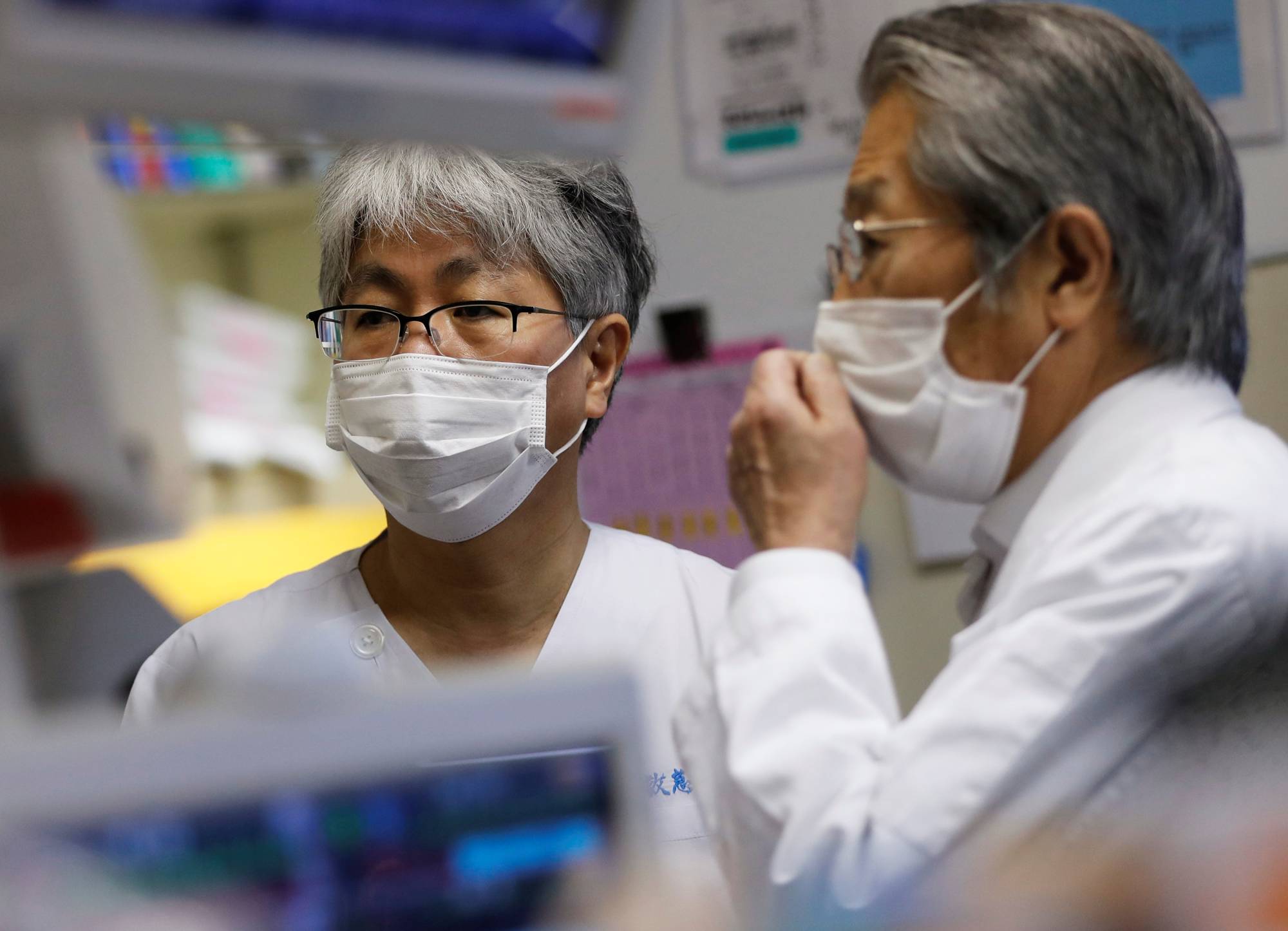 Dr. Shigeki Fujitani (left), the director of the Intensive Care Unit, talks with his predecessor, Dr. Yasuhiko Taira, at the ICU for COVID-19 patients at St. Marianna Medical University Hospital in Kawasaki on May 4. | REUTERS