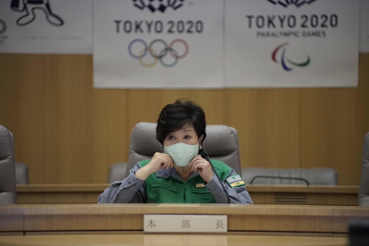 Tokyo Gov. Yuriko Koike adjusts her mask during a meeting of the metropolitan government's coronavirus task force on Friday following her announcement of the city's plan to reopen the capital after the possible lifting of the state of emergency on Monday. | RYUSEI TAKAHASHI