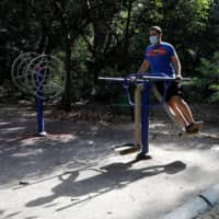A man exercises at a park in New Delhi on Friday. Japan on Friday raised its travel advisory for 11 countries including India to Level 3, urging against any trips to the areas. | REUTERS