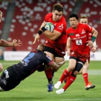 The Sunwolves\' Gerhard van den Heever tries to avoid a tackle during a Super Rugby match on Feb. 23 in Singapore. | REUTERS