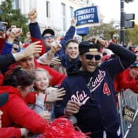 Nationals manager Dave Martinez celebrates with fans during the team\'s World Series celebration parade on Nov. 2 in Washington. | AP