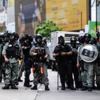 Riot police stand guard as protesters attend a pro-democracy rally against a proposed new security law in Hong Kong on Sunday. | AFP-JIJI