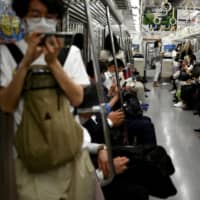 Commuters ride a train in Tokyo on Monday. | AFP-JIJI