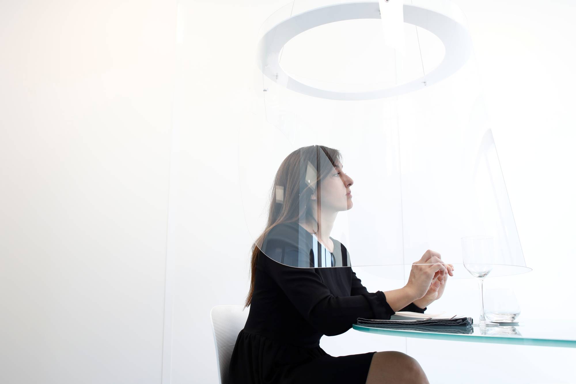 A woman poses under a Plex'Eat prototype plexiglass bubble by designer Christophe Gernigon during a presentation in Cormeilles-en-Parisis, near Paris. | REUTERS