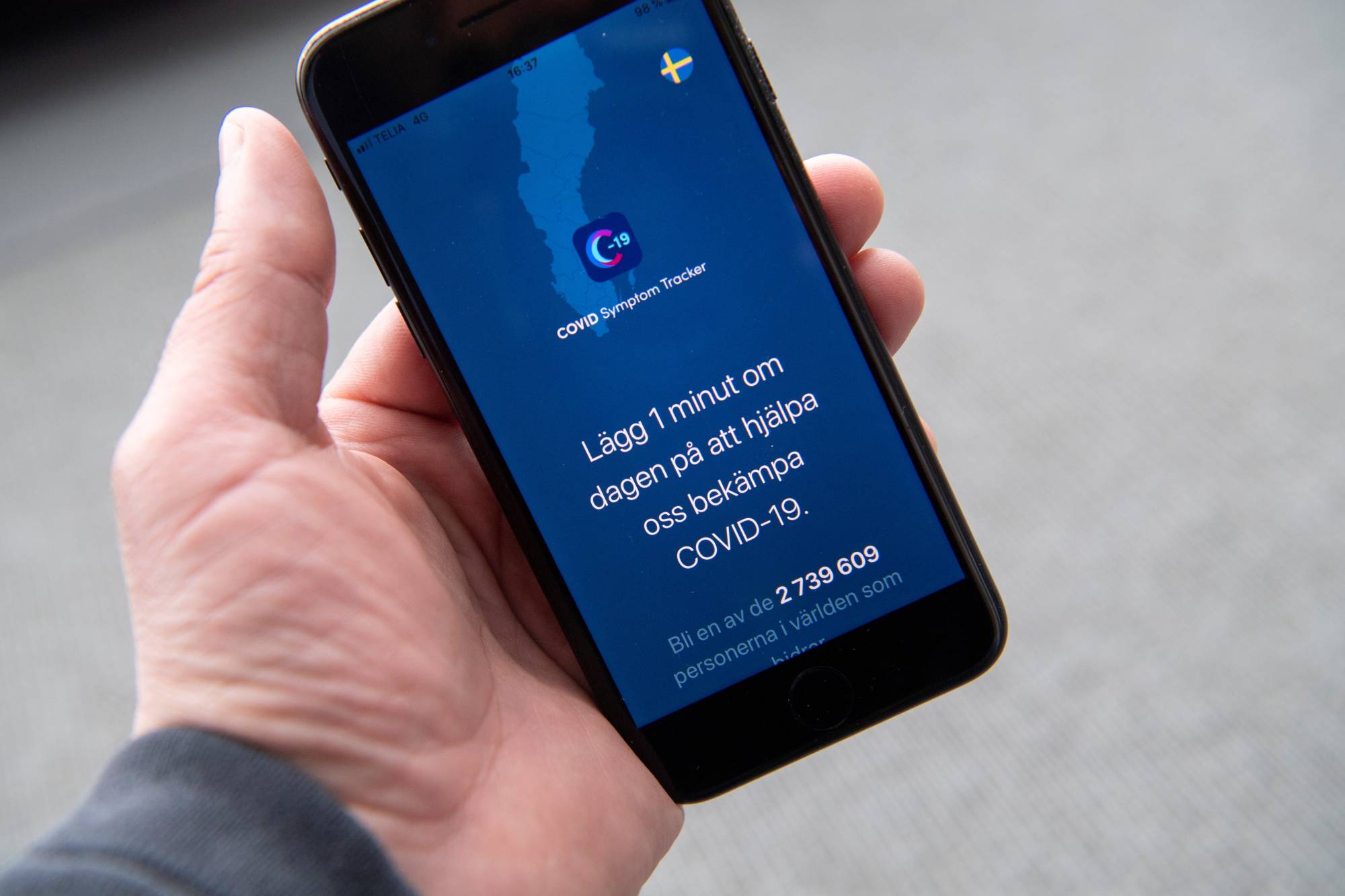 A man uses a Swedish version of the Covid Symptom Tracker app on his smartphone in Stockholm on April 29. | TT NEWS AGENCY / VIA REUTERS