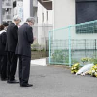 School officials offer prayers in Kawasaki on Thursday, one year after a stabbing rampage that targeted schoolchildren and parents in the city. | KYODO