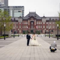 While the state of emergency forced an abrupt change to most people’s lives, some saw the empty city as an opportunity. Here a couple uses an empty Tokyo Station as a backdrop for their wedding photos. On average, more than 500,000 people use Tokyo Station every day.  | OSCAR BOYD
