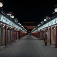The shopping arcade leading to Sensoji Temple, one of Tokyo’s most prominent tourist sites. Behind each set of shutters is a shop that usually sells trinkets to visitors. With a 99.9 percent drop in tourists and borders yet to open, most remain shuttered even now. | OSCAR BOYD