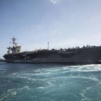 The aircraft carrier USS Theodore Roosevelt departs Naval Base Guam on May 21 on a training mission after being sidelined with a coronavirus outbreak for nearly two months. | U.S. MARINE CORPS /VIA AP