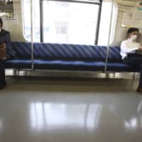 Train passengers practice social distancing. Tokyo reported 22 new infections Friday. | AP