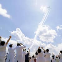 The Air Self-Defense Force\'s Blue Impulse acrobatics corps flies over Tokyo on Friday afternoon to express appreciation to medical workers on the frontlines fighting the COVID-19 pandemic, as medical staff of Self-Defense Forces Central Hospital in Setagaya Ward look at the performance. | KYODO