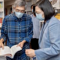 Taiwan\'s President Tsai Ing-wen looks at a book while visiting Lam Wing-kee, a bookseller from Hong Kong who in 2015 was detained in China for allegedly bringing banned books into the mainland.  | TAIWAN PRESIDENTIAL OFFICE / VIA AFP-JIJI