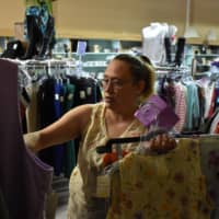 Shannon Thompson looks through clothing items at the Northern Treasure thrift store last Monday in Roundup, Montana. | AP