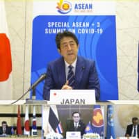 In this screen grab from a video provided by Vietnamese national television network VTV, Prime Minister Shinzo Abe speaks to ASEAN Plus Three leaders during a virtual summit in April.   | VTV / VIA AP
