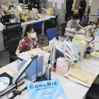 Environment Ministry officials, dressed more casually than usual, work in Tokyo on Friday, at the start of the 16th annual \"Cool Biz\" campaign that is part of efforts to reduce energy use nationwide. | KYODO