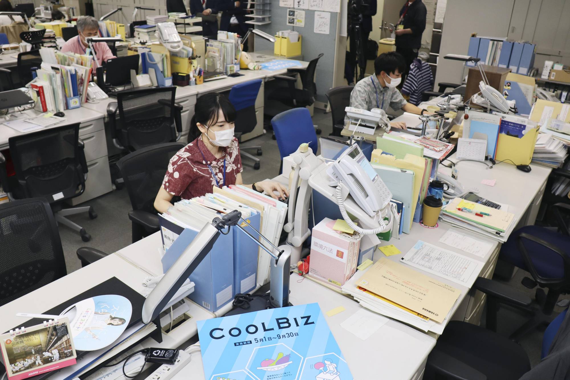 Environment Ministry officials, dressed more casually than usual, work in Tokyo on Friday, at the start of the 16th annual 'Cool Biz' campaign that is part of efforts to reduce energy use nationwide. | KYODO