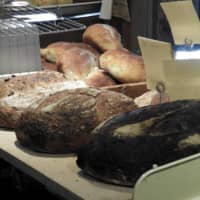 Fresh from the oven: Loaves of olive sourdough (right), Hokkaido wheat (center) and campagne (French sourdough) sit cooling on blocks in Lee\'s Bread.  | JOAN BAILEY
