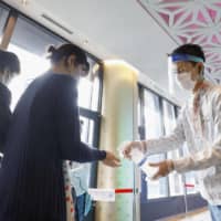 Visitors disinfect their hands at Tokyo Skytree on Monday, as the tower reopens after being closed due to the coronavirus pandemic. | KYODO