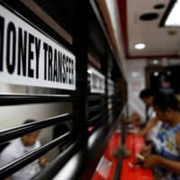 Customers receive money from family members working abroad at a remittance center in Makati City, Metro Manila, the Philippines, in 2018.  | REUTERS 