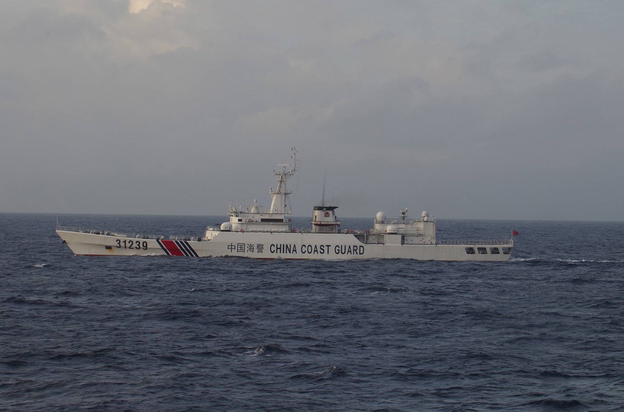An armed China Coast Guard vessel is seen sailing near the Senkaku Islands for the first time on Dec. 22, 2015. The activities of CCG ships around the Senkaku islets have increased markedly in recent years.  | JAPAN COAST GUARD / VIA REUTERS