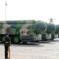 Military vehicles carrying DF-41 intercontinental ballistic missiles travel past Beijing\'s Tiananmen Square during a military parade marking the 70th founding anniversary of the People\'s Republic of China on October 1 last year. | REUTERS