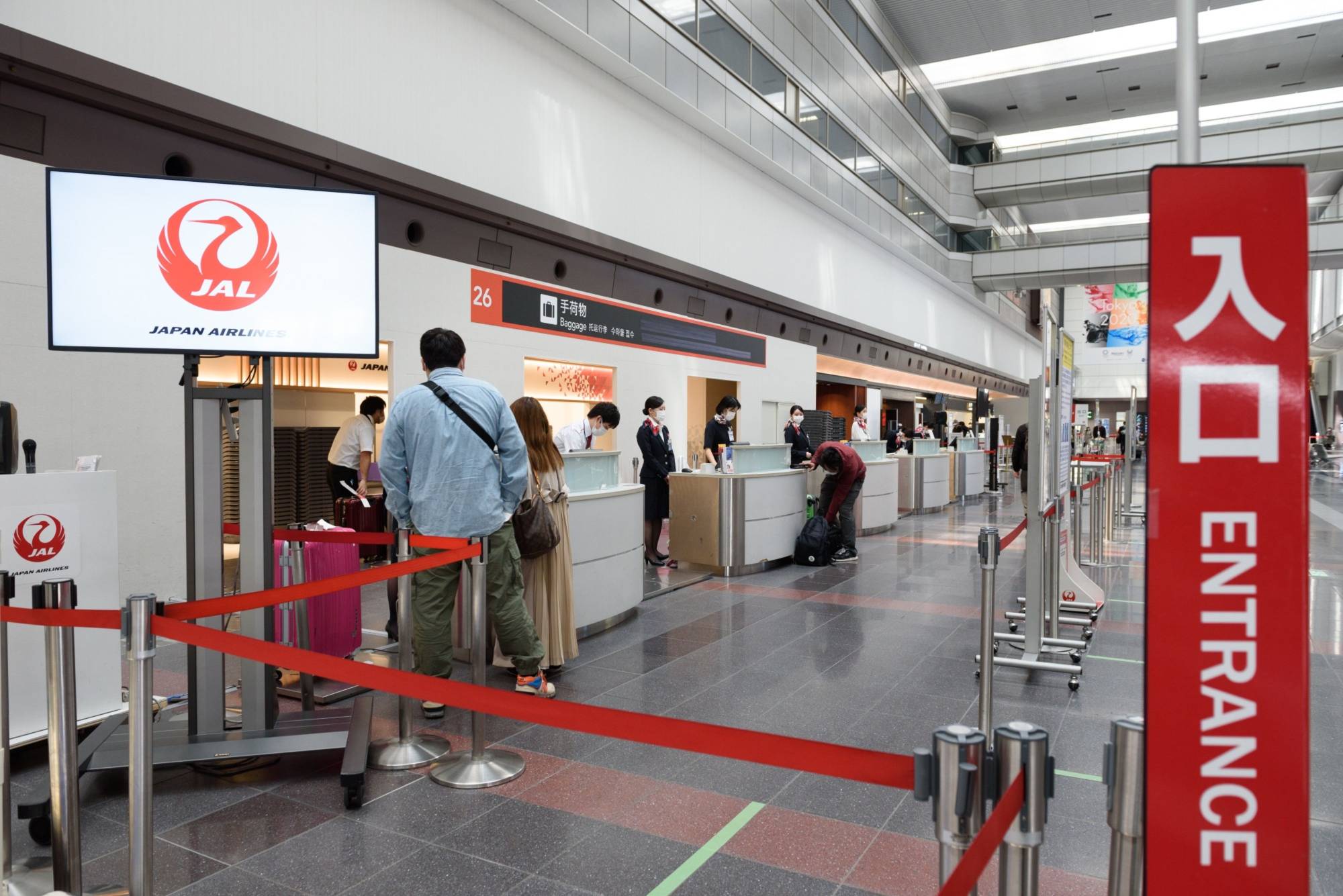 Passengers check in their luggage at Japan Airlines Co. counters at Haneda Airport in Tokyo. | BLOOMBERG