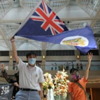A pro-democracy demonstrator waves the British colonial Hong Kong flag during a protest against new national security legislation in the city on Monday.  | REUTERS