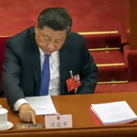 Chinese President Xi Jinping votes on national security legislation concerning Hong Kong during the closing session of China\'s National People\'s Congress in Beijing on Thursday. | AP