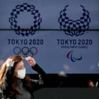 A screen in Tokyo displays the logos for the 2020 Summer Olympics and Paralympics. | REUTERS