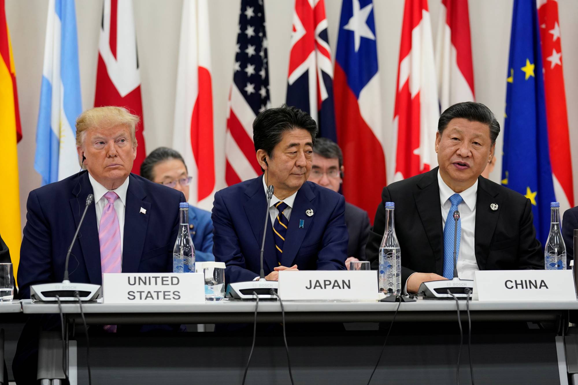 Prime Minister Shinzo Abe is flanked by U.S. President Donald Trump and Chinese leader Xi Jinping during a meeting at the Group of 20 summit in Osaka in June last year. | REUTERS