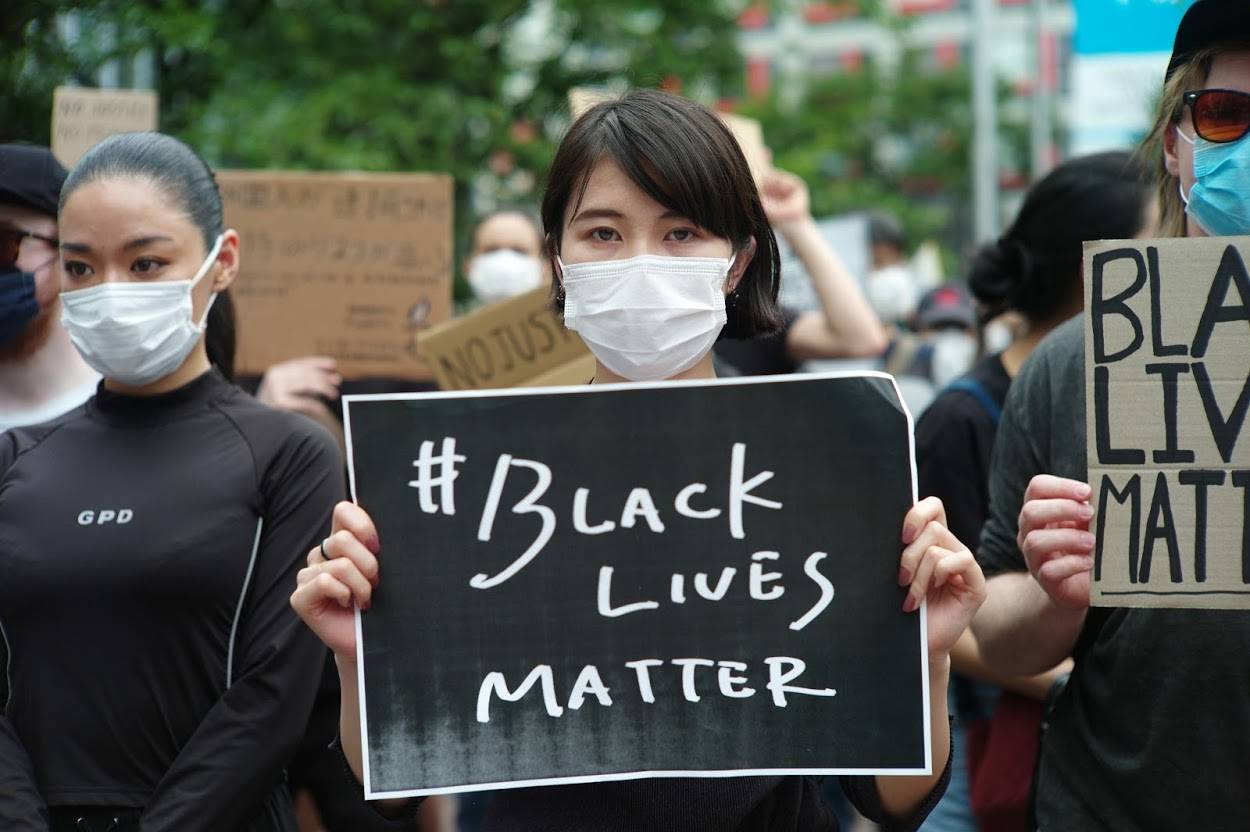 A woman holds a sign during the Black Lives Matter protest Saturday in Tokyo. | RYUSEI TAKAHASHI