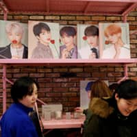 Fans of K-pop idol boy band BTS shop at a pop-up store selling BTS goods in Seoul last December. | REUTERS