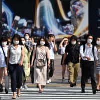 People walk across Shibuya crossing in Tokyo on Monday. | AFP-JIJI