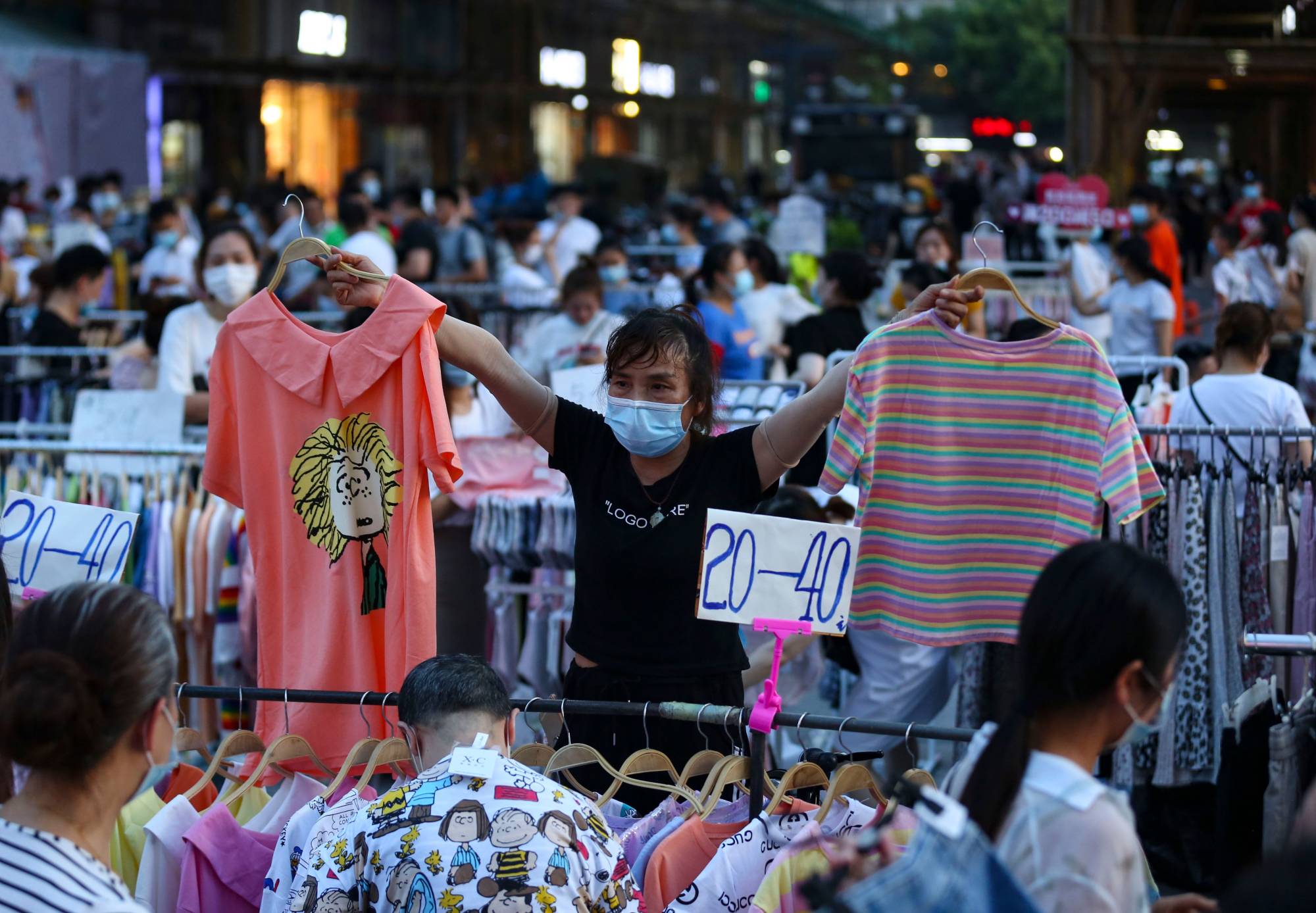 A street vendor sells clothes at an outdoor market in Wuhan on Monday.  | STR / VIA AFP-JIJI