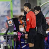 The referee looks into the screen of VAR system during a J. League match between Shonan Bellmare and Urawa Reds on Feb. 21 at BMW Stadium in Hiratsuka, Kanagawa Prefecture. | KYODO