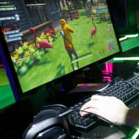 A person plays the Fortnite online video game developed by Epic Games, in which China\'s Tencent Holdings Ltd. has a stake. Tencent is reportedly targeting Japan\'s anime and manga in a bid to spur the company\'s global growth. | BLOOMBERG