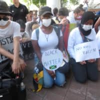 Take part: People kneel in a moment of silence to remember victims of police brutality in the United States at a march in Osaka on June 7. | ERIC JOHNSTON
