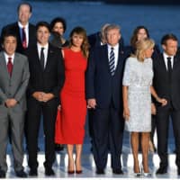 French President Emmanuel Macron and his wife, Brigitte Macron, U.S. President Donald Trump and First Lady Melania Trump, Prime Minister Shinzo Abe, Canadaian Prime Minister Justin Trudeau and German Chancellor Angela Merkel pose for a photo with guests during the G7 summit in Biarritz, France, on Aug. 25. | POOL / VIA REUTERS