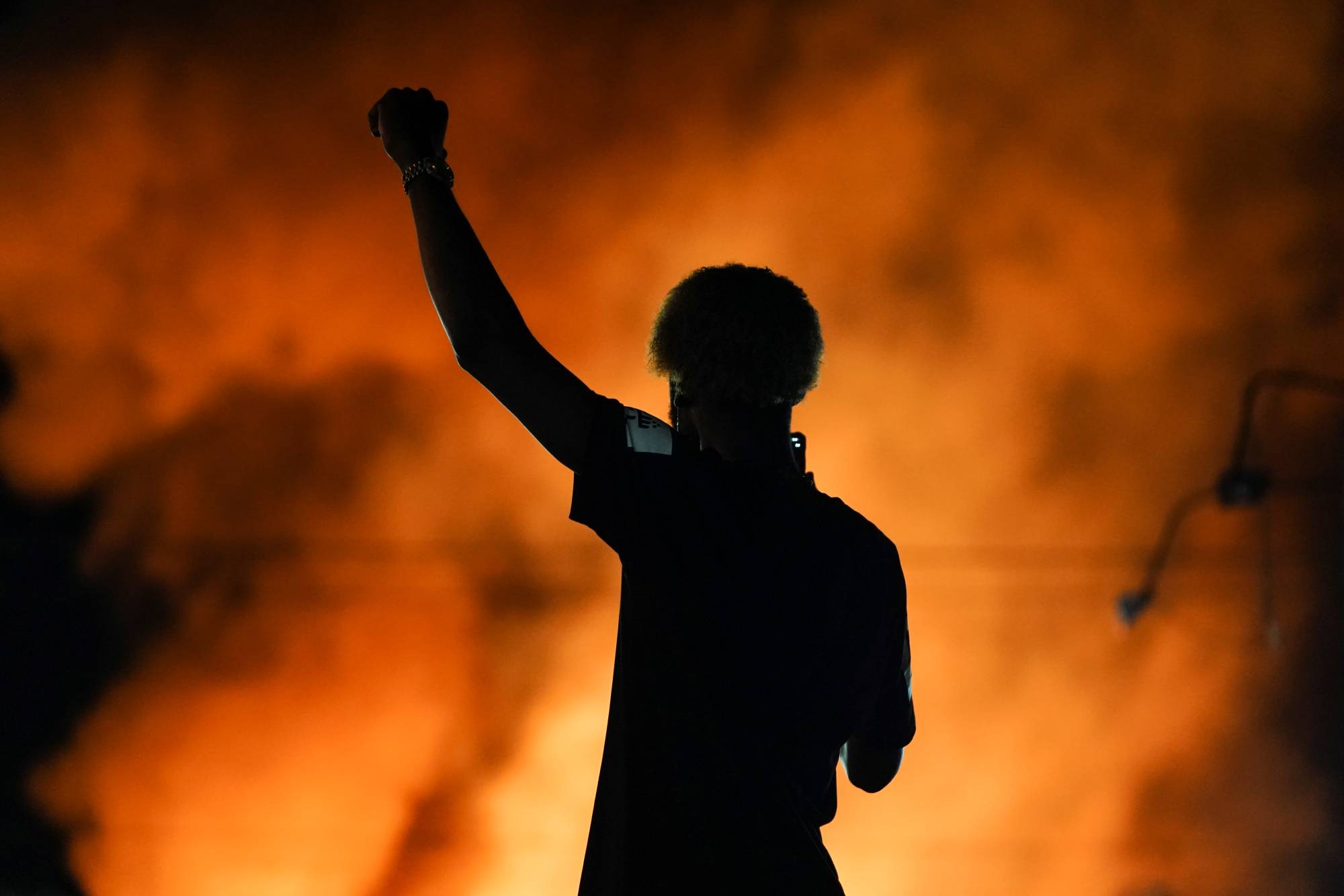A protester watches as a Wendy’s burns Saturday following the police shooting death of Rayshard Brooks in Atlanta.  | REUTERS