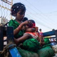 A girl holds a baby at the Aung Mingalar quarter for Rohingya Muslims in Sittwe in Myanmar\'s Rakhine state last month.  | AFP-JIJI