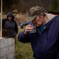 Hanson Rowe, a landowner who blames a leaky gas well on his property for health problems, smells water drawn from a contaminated well on his property in Salyersville, Kentucky, in February.  | REUTERS 