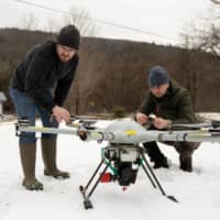 Timothy De Smet and Alex Nikulin prepare a Ukrainian Multirotor Technologies  Cicada-M drone to fly with a magnetometer to detect abandoned oil wells in Olean, New York. | REUTERS 