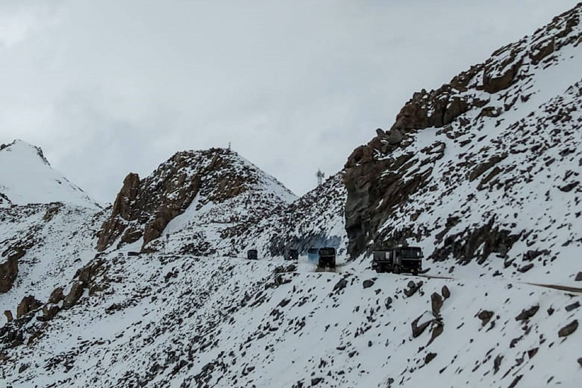 Indian Army vehicles transit the Chang La mountain pass in Kashmir near the border with China on Wednesday. Beijing and New Delhi held top level talks that day to 'cool down the situation' following a violent border brawl on Monday that left at least 20 Indian soldiers dead. | AFP-JIJI