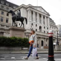 A pedestrian walks past the Bank of England in London on Tuesday. The nation\'s central bank has apologized for the involvement of some of its former governors and directors in the slave trade. | AFP-JIJI