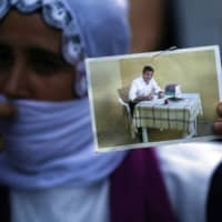A supporter of the pro-Kurdish People\'s Democratic Party holds a picture of the party\'s former leader Selahattin Demirtas during a rally in Istanbul on Thursday. | AP