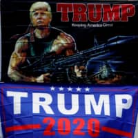 A man walks past banners of U.S. President Donald Trump near the BOK Center in Tulsa, Oklahoma, on Friday, a day ahead of Trump\'s planned rally in the city. | REUTERS