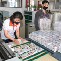 This undated picture released Saturday shows North Koreans preparing anti-Seoul leaflets that will be sent into the South as tensions soar on the Korean Peninsula. | KCNA / KNS / VIA AFP-JIJI