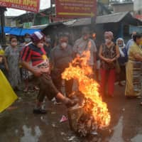 Indian activists along with Tibetans living in exile shout anti-Chinese slogans as they burn Chinese flags and poster depicting President Xi Jinping during an anti-China demonstration in Siliguri, India, on Saturday. | AFP-JIJI