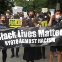 Participants of Black Lives Matter march in Kyoto hold a banner on Sunday.  | ERIC JOHNSTON
